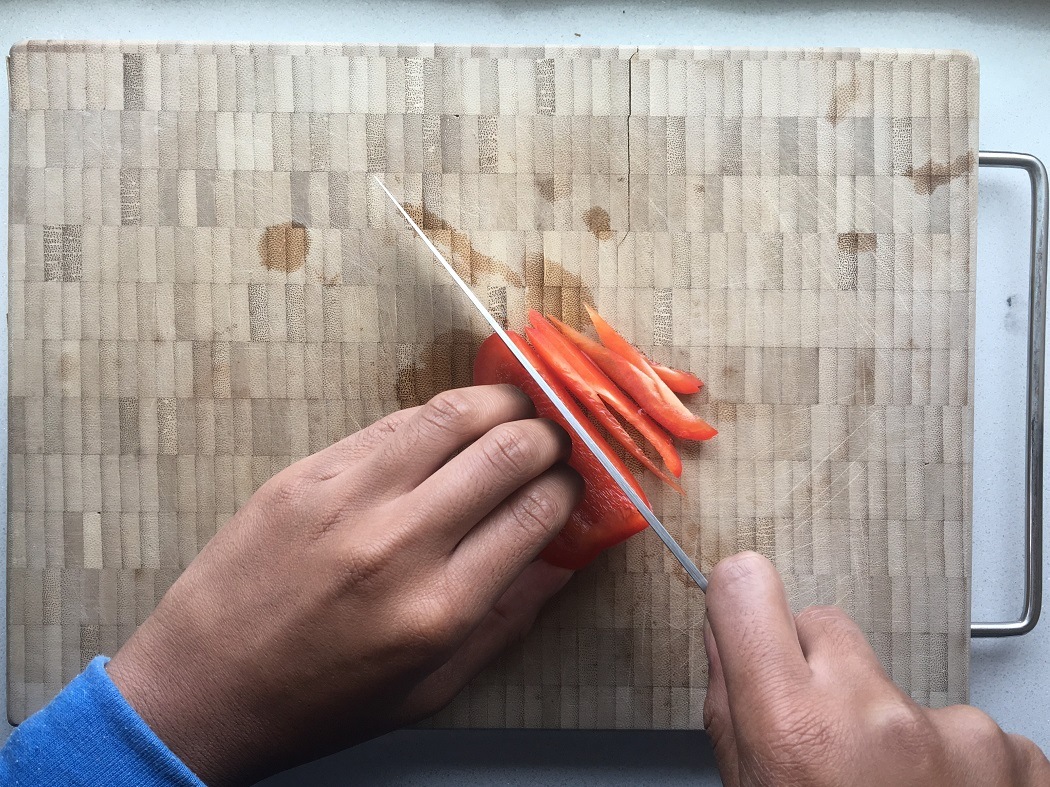 Een paprika die julienne gesneden wordt